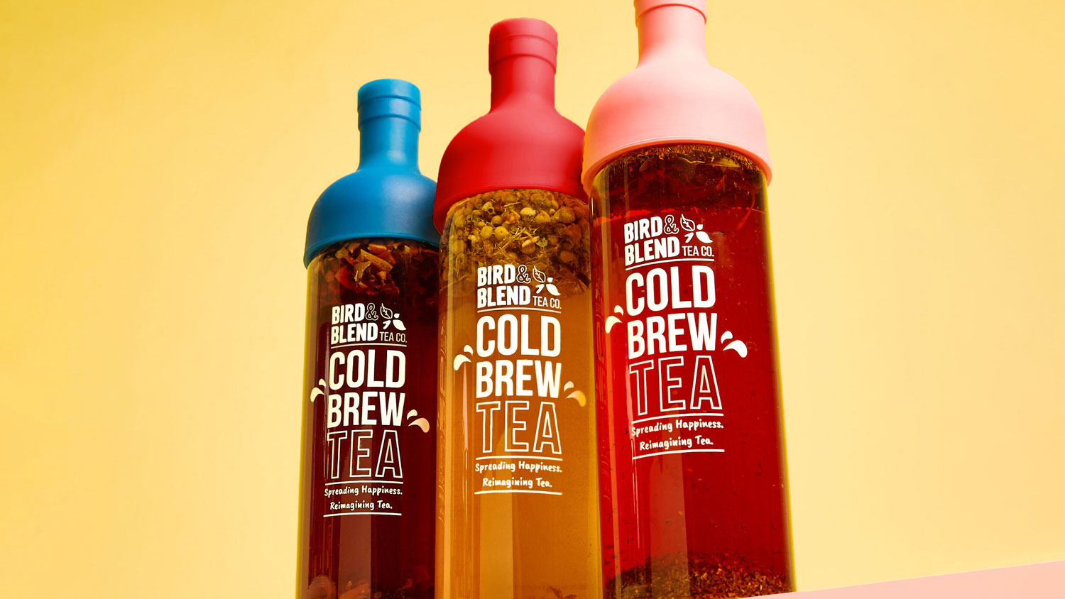 cold brew bottles in blue, red and pink